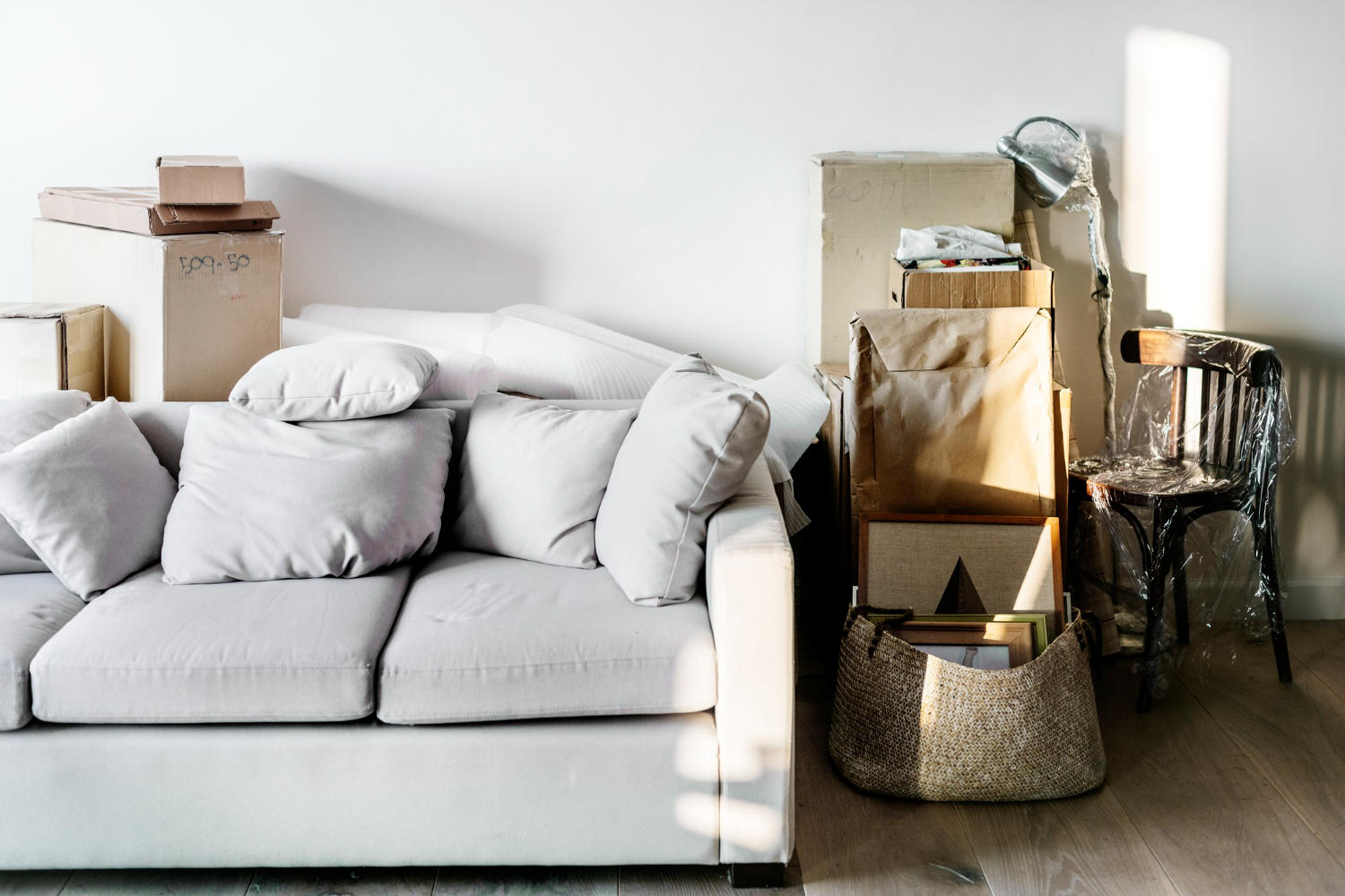 Salon en déménagement avec cartons et canapé gris, service etoile spécialisé dans le Tarn